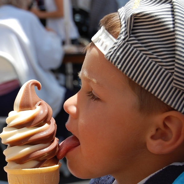 Boy enjoying vanilla chocolate twist ice cream cone